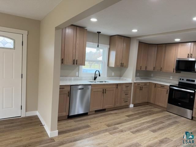 20 S Erie St, Aurora, MN 55705 - kitchen featuring stainless steel appliances, light wood-style floors, light countertops, decorative light fixtures, and recessed lighting