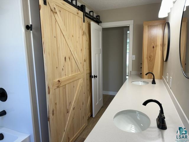 20 S Erie St, Aurora, MN 55705 - bathroom featuring double vanity and shower / bath combination