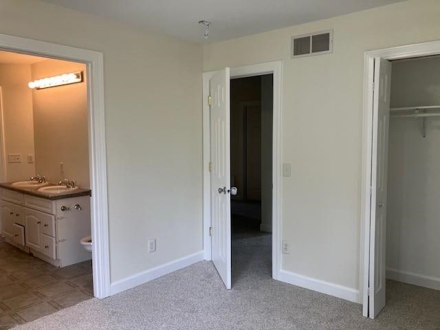 34358 State Highway 18, Finlayson, MN 55735 - unfurnished bedroom featuring a closet, a spacious closet, ensuite bathroom, and light carpet