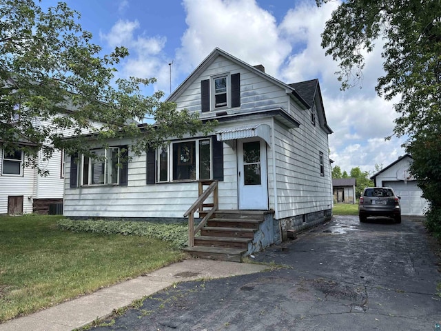 403 E Camp St, Ely, MN 55731 - view of front of house with entry steps, a front lawn, and an outdoor structure