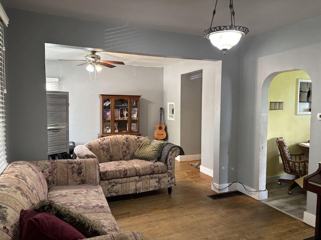 403 E Camp St, Ely, MN 55731 - living room with arched walkways, ceiling fan, and wood finished floors