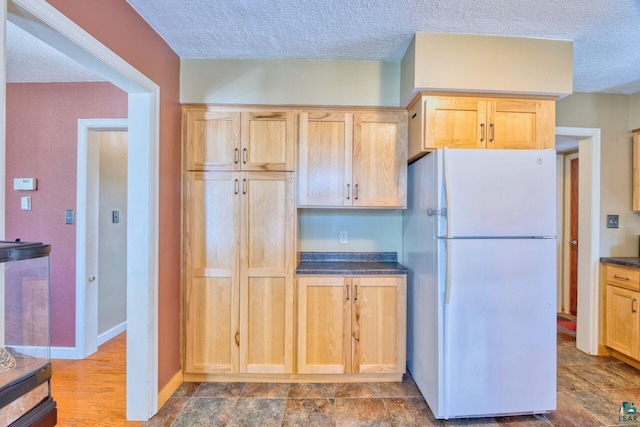 305 W Central Ave, Aurora, MN 55705 - kitchen with freestanding refrigerator, dark countertops, light brown cabinetry, and a textured ceiling