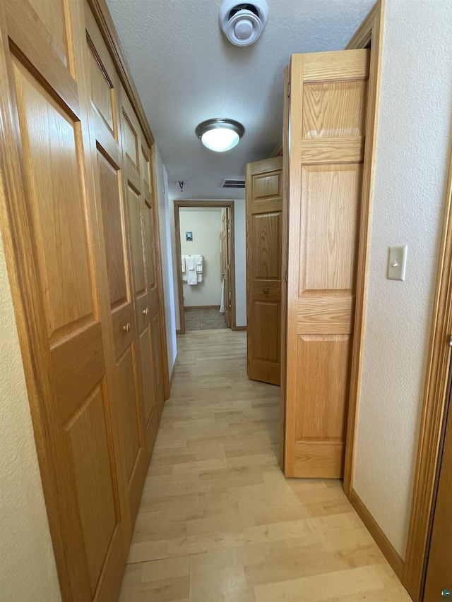 34 N 2nd St Unit 2, Bayfield, WI 54814 - hall with light wood-style floors, a textured wall, and a textured ceiling