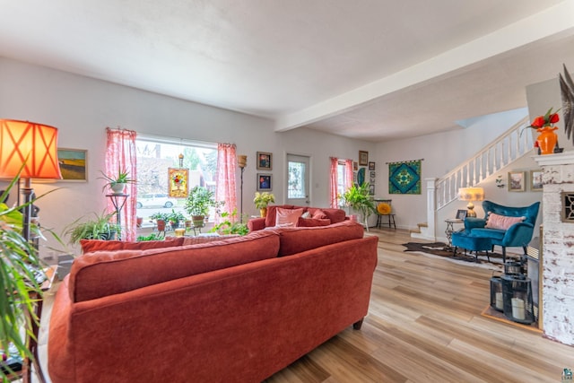 343 E Harvey St, Ely, MN 55731 - living room with light wood-type flooring, beamed ceiling, stairs, and a fireplace