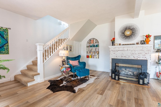 343 E Harvey St, Ely, MN 55731 - living area featuring stairs, wood finished floors, and a brick fireplace