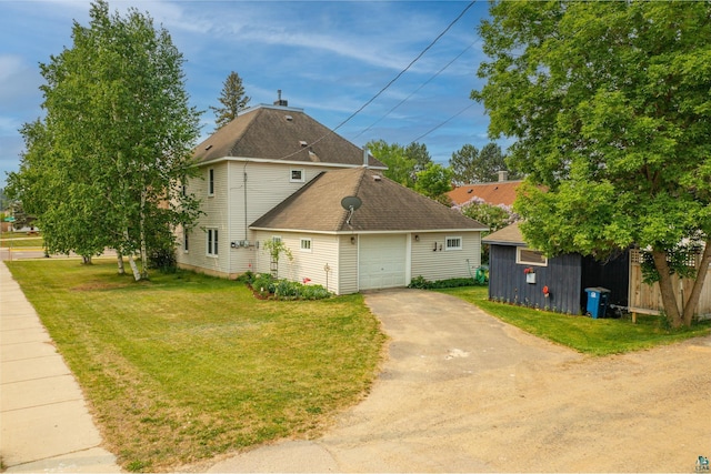 343 E Harvey St, Ely, MN 55731 - view of side of home featuring driveway, a yard, a garage, and a shingled roof