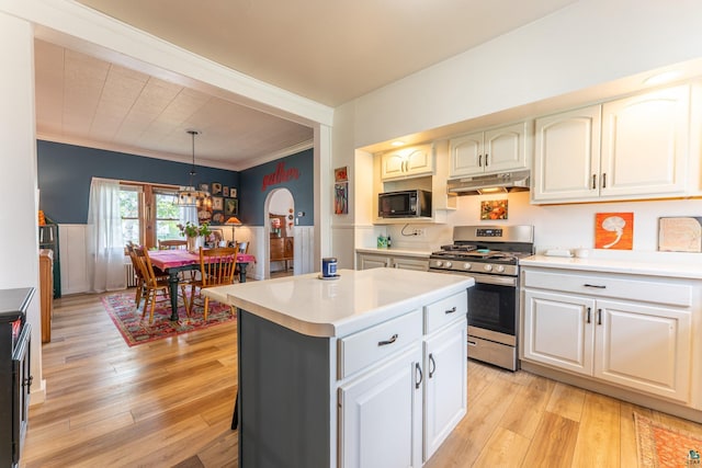 343 E Harvey St, Ely, MN 55731 - kitchen with black microwave, stainless steel gas range oven, under cabinet range hood, light countertops, and light wood-style floors