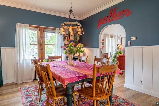 343 E Harvey St, Ely, MN 55731 - dining area with a chandelier, arched walkways, radiator heating unit, wainscoting, and crown molding
