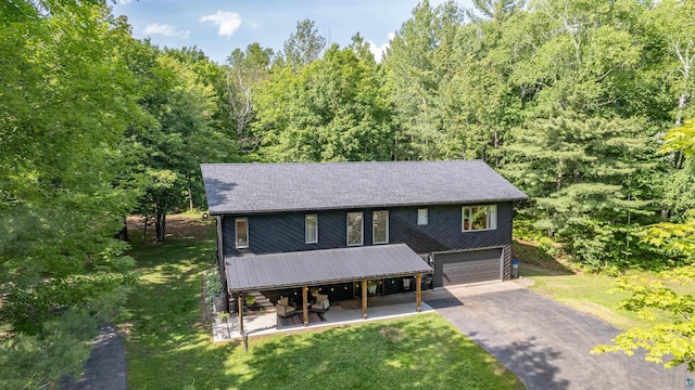 4921 W Pioneer Rd, Duluth, MN 55803 - view of front of property with driveway, a garage, a front yard, and a view of trees