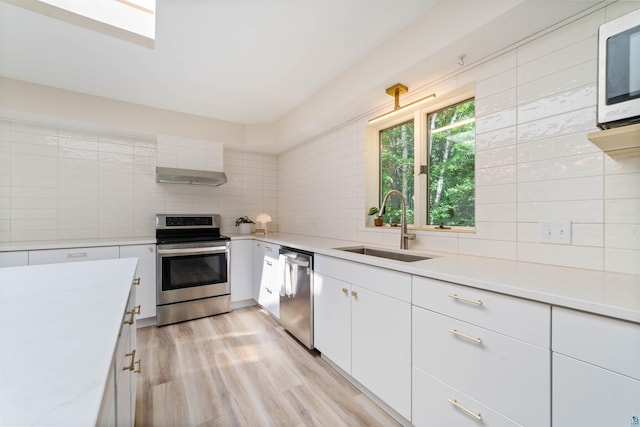 4921 W Pioneer Rd, Duluth, MN 55803 - kitchen featuring appliances with stainless steel finishes, backsplash, light countertops, and white cabinetry