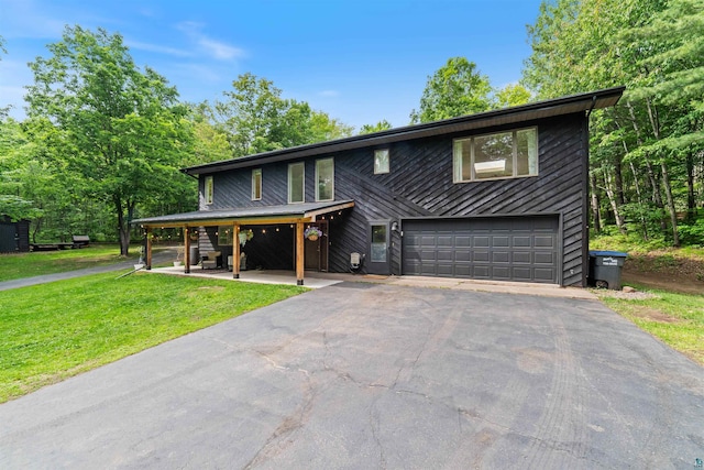 4921 W Pioneer Rd, Duluth, MN 55803 - view of front of house featuring an attached garage, asphalt driveway, and a front yard