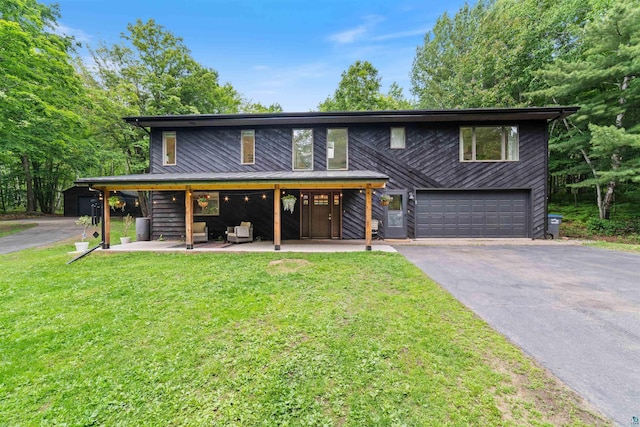 4921 W Pioneer Rd, Duluth, MN 55803 - view of front of home featuring asphalt driveway, a garage, and a front yard