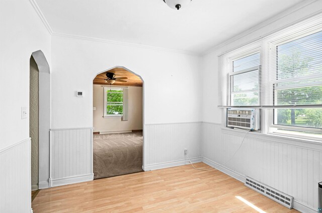1707 Swan Lake Rd, Duluth, MN 55811 - spare room with arched walkways, a wainscoted wall, a ceiling fan, cooling unit, and light wood-style flooring