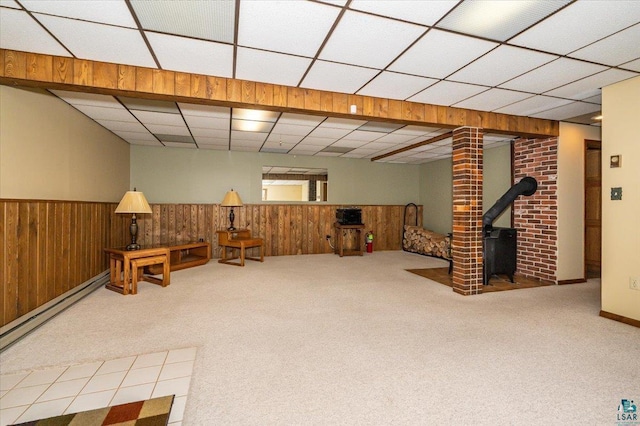 1819 Yosemite Ave, Duluth, MN 55811 - unfurnished room featuring a wood stove, a paneled ceiling, carpet flooring, baseboard heating, and wainscoting