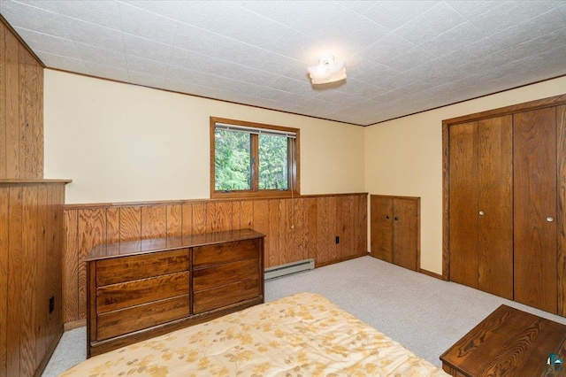 1819 Yosemite Ave, Duluth, MN 55811 - carpeted bedroom featuring a baseboard radiator, wood walls, wainscoting, and a closet
