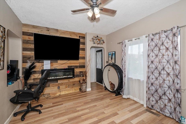 2973 Devonshire St, Duluth, MN 55806 - office area featuring ceiling fan, a textured ceiling, wood finished floors, arched walkways, and a fireplace
