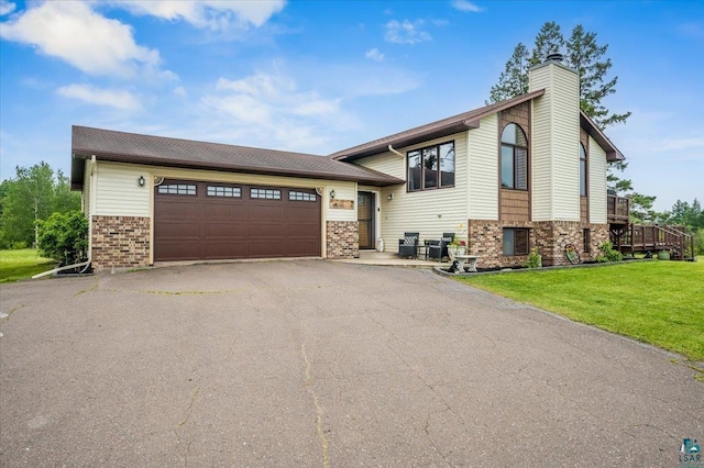 140 E Harney Rd, Esko, MN 55733 - view of front of house featuring brick siding, driveway, an attached garage, a chimney, and a front lawn