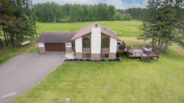 140 E Harney Rd, Esko, MN 55733 - view of front of house featuring stone siding, a front lawn, asphalt driveway, a garage, and a deck