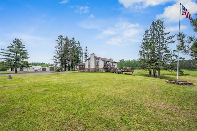 140 E Harney Rd, Esko, MN 55733 - view of green lawn with a garage, asphalt driveway, and a wooden deck