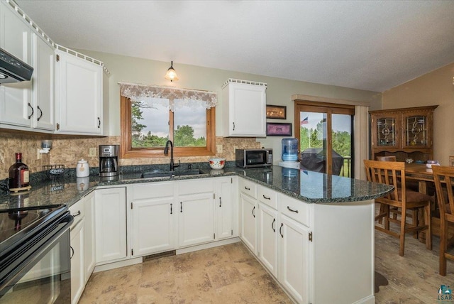 140 E Harney Rd, Esko, MN 55733 - kitchen featuring stainless steel microwave, a peninsula, backsplash, white cabinets, and dark stone countertops