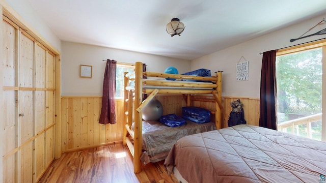 XX3 Sugar Bush Trl, Orr, MN 55771 - bedroom with multiple windows, wooden walls, a wainscoted wall, and wood finished floors