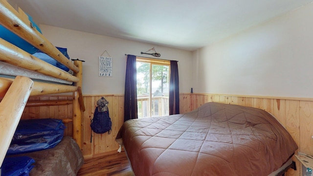 XX3 Sugar Bush Trl, Orr, MN 55771 - bedroom featuring a wainscoted wall, wooden walls, access to outside, and wood finished floors