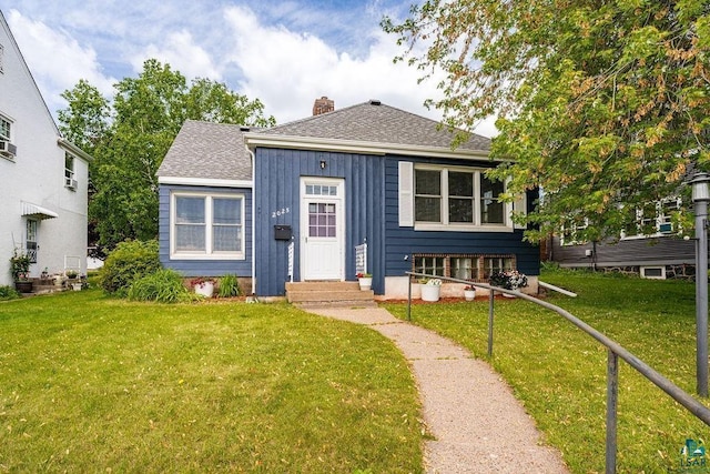 2025 E 8th St, Duluth, MN 55812 - bungalow featuring a chimney, a front yard, board and batten siding, and roof with shingles
