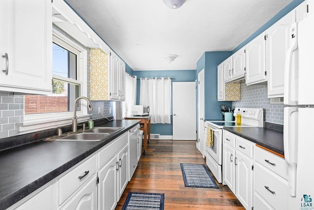 2025 E 8th St, Duluth, MN 55812 - kitchen featuring white appliances, dark countertops, white cabinets, and tasteful backsplash