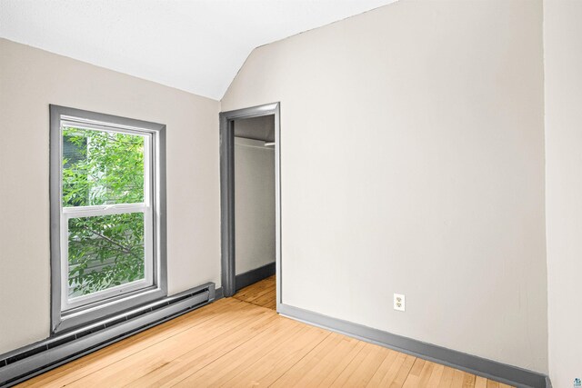 2626 W 5th St, Duluth, MN 55806 - unfurnished bedroom with a baseboard heating unit, hardwood / wood-style flooring, and lofted ceiling