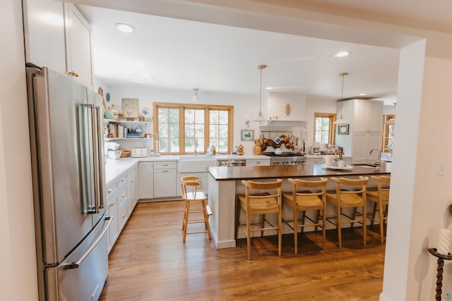 27 Ryan Ln, Esko, MN 55733 - kitchen with stainless steel appliances, a breakfast bar, light wood-style flooring, white cabinets, and recessed lighting