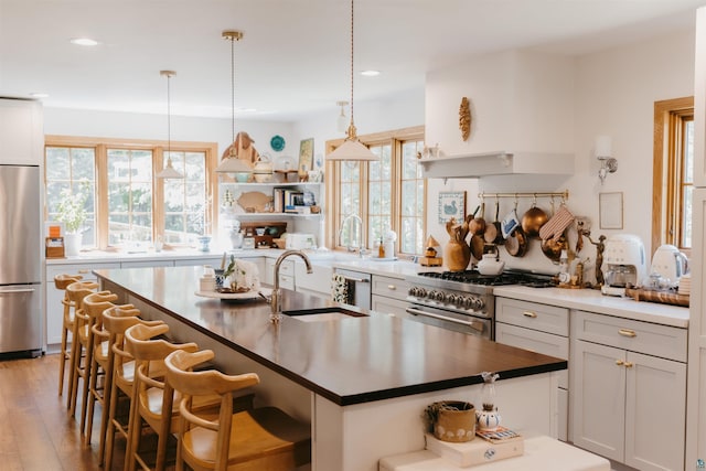 27 Ryan Ln, Esko, MN 55733 - kitchen with appliances with stainless steel finishes, open shelves, recessed lighting, a kitchen breakfast bar, and light wood-type flooring