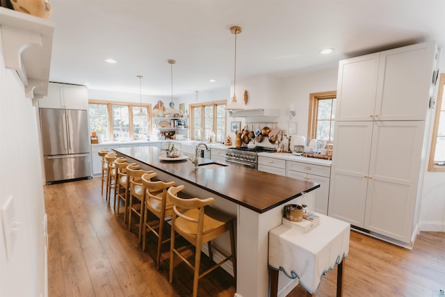 27 Ryan Ln, Esko, MN 55733 - kitchen with appliances with stainless steel finishes, a breakfast bar area, light wood-type flooring, an island with sink, and recessed lighting