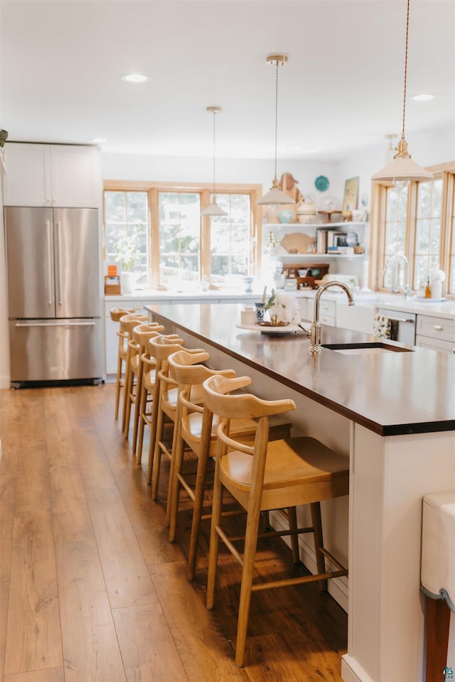 27 Ryan Ln, Esko, MN 55733 - kitchen featuring freestanding refrigerator, white cabinets, light wood-style flooring, recessed lighting, and hanging light fixtures
