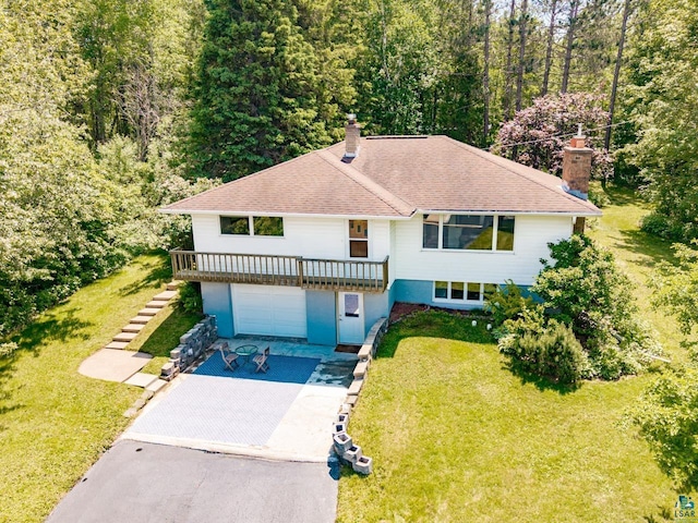 4750 Morris Thomas Rd, Hermantown, MN 55811 - view of front facade with a chimney, asphalt driveway, a front lawn, and an attached garage
