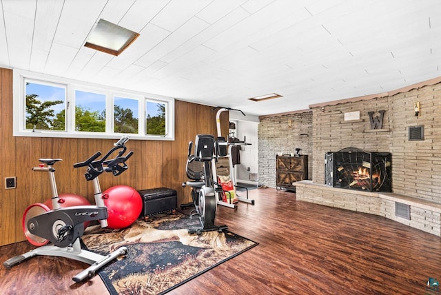 4750 Morris Thomas Rd, Hermantown, MN 55811 - workout area featuring wood finished floors, a fireplace, and wooden walls