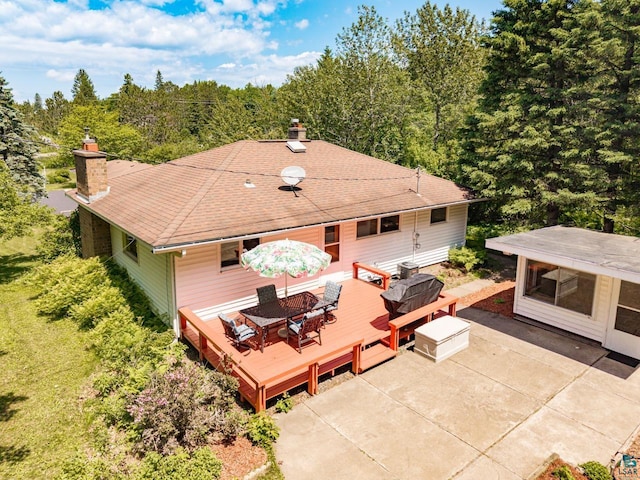 4750 Morris Thomas Rd, Hermantown, MN 55811 - rear view of property featuring a chimney, a wooden deck, a patio, a view of trees, and outdoor dining area