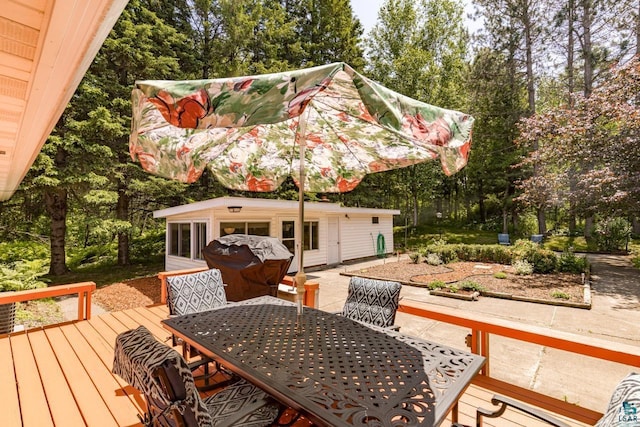 4750 Morris Thomas Rd, Hermantown, MN 55811 - wooden terrace featuring outdoor dining space, view of scattered trees, and an outdoor structure