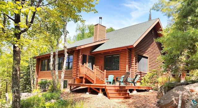 2357 Retreat Lodge Rd, Cook, MN 55723 - view of front facade with log exterior, a chimney, roof with shingles, and stairs