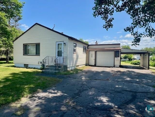 612 23rd St, Cloquet, MN 55720 - view of front of house with driveway, a garage, a front yard, and a carport