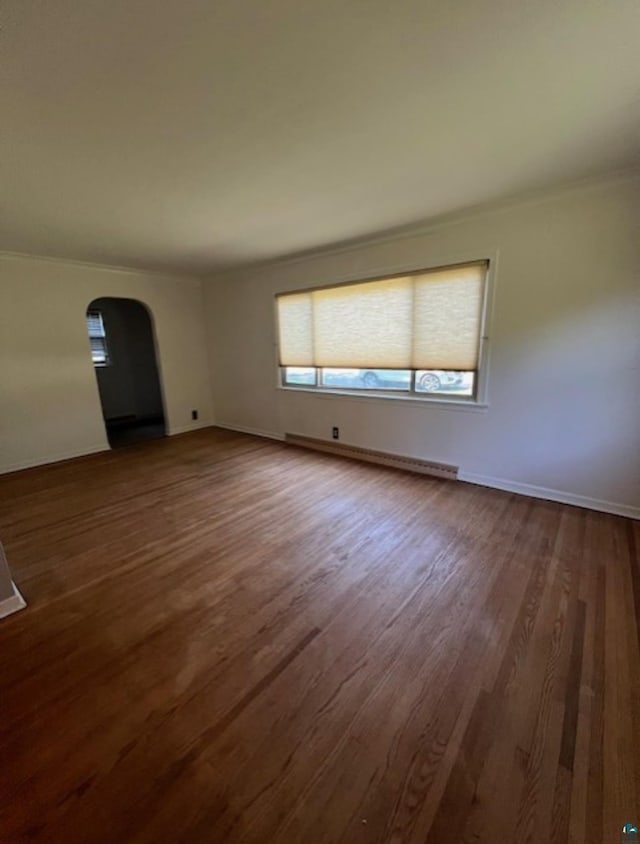 612 23rd St, Cloquet, MN 55720 - spare room with arched walkways, dark wood-style floors, baseboard heating, and crown molding