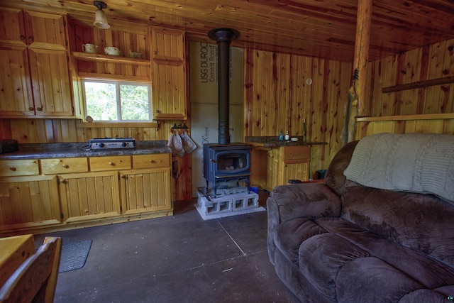 4194 First Lake Rd, Ely, MN 55731 - kitchen featuring a wood stove, concrete flooring, dark countertops, and wooden walls