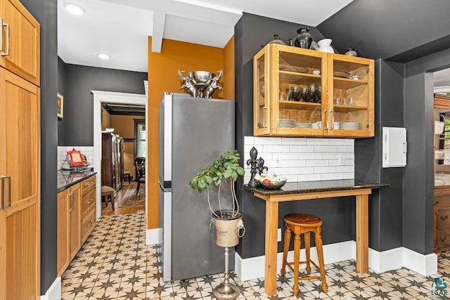 2319 E 4th St, Duluth, MN 55812 - kitchen featuring freestanding refrigerator, light flooring, tasteful backsplash, and glass insert cabinets