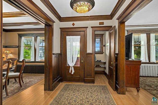 2319 E 4th St, Duluth, MN 55812 - foyer entrance with radiator, wainscoting, light wood-style floors, and crown molding