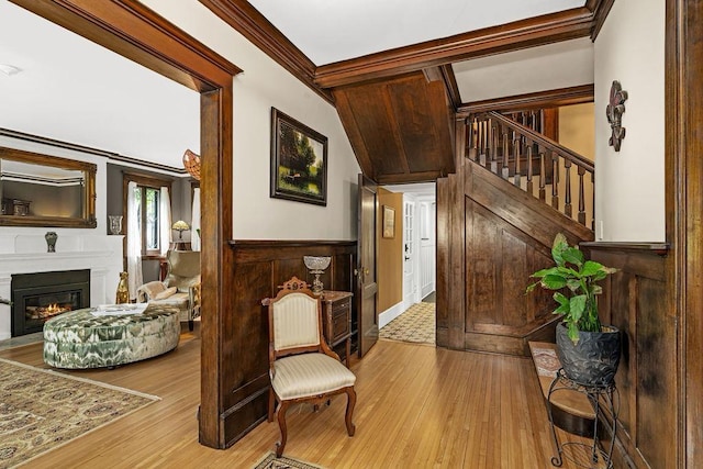 2319 E 4th St, Duluth, MN 55812 - foyer entrance with hardwood / wood-style flooring, wainscoting, a glass covered fireplace, ornamental molding, and stairway