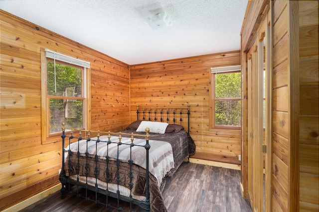 1612 Pequaywan Lake Rd, Ault, MN 55602 - bedroom featuring multiple windows, dark wood finished floors, wooden walls, and a textured ceiling