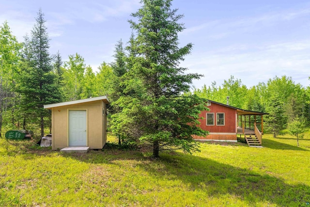 1612 Pequaywan Lake Rd, Ault, MN 55602 - view of green lawn with a shed, a deck, and a view of trees