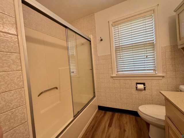 35 E Faribault St, Duluth, MN 55803 - full bath with tile walls, wood finished floors, vanity, enclosed tub / shower combo, and wainscoting