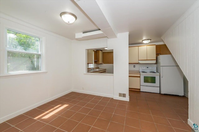 3731 W 2nd St, Duluth, MN 55807 - kitchen with white appliances, tile patterned flooring, under cabinet range hood, and light countertops