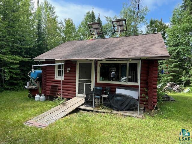 2217 Michael Beach Rd, Zim, MN 55738 - back of property with log exterior, roof with shingles, and a lawn