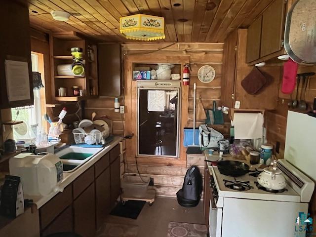 2217 Michael Beach Rd, Zim, MN 55738 - kitchen with white gas range oven, wood ceiling, light countertops, open shelves, and wooden walls